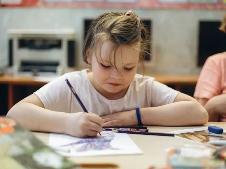 Bright art studio with vibrant paintings, drawing people of all ages creating art together.